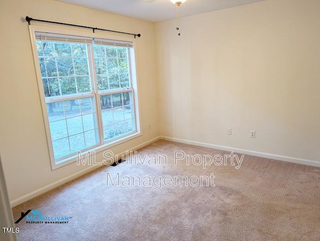 spare room featuring carpet flooring and baseboards