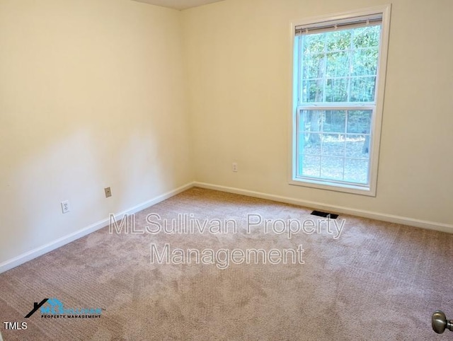 carpeted empty room featuring visible vents and baseboards