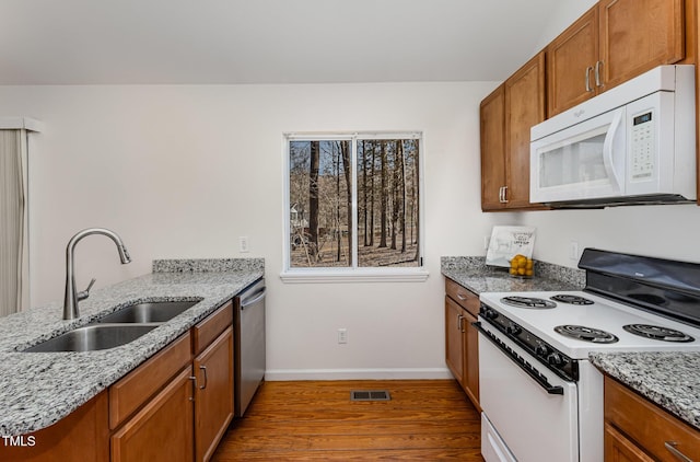 kitchen featuring white microwave, a sink, dark wood-style floors, electric stove, and dishwasher