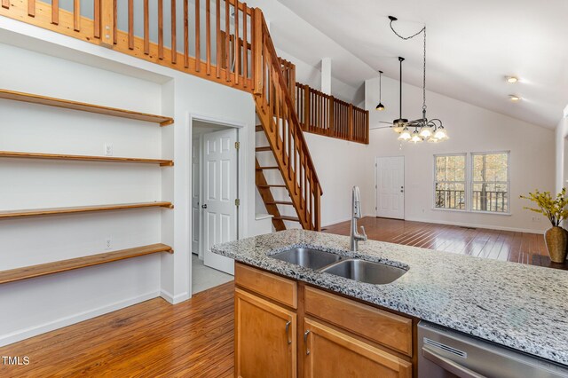 kitchen featuring a sink, hardwood / wood-style flooring, open shelves, and dishwasher