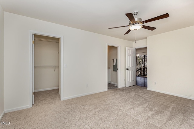 unfurnished bedroom featuring connected bathroom, carpet floors, baseboards, a closet, and a walk in closet