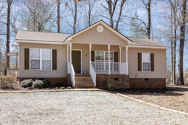 view of front of house featuring crawl space, covered porch, and a shingled roof