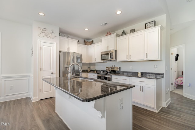 kitchen featuring a center island with sink, stainless steel appliances, white cabinets, a breakfast bar, and sink