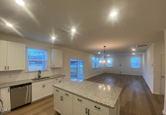 kitchen featuring a center island, white cabinetry, dishwasher, and sink