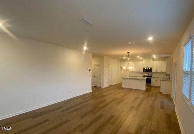 unfurnished living room featuring sink and hardwood / wood-style floors