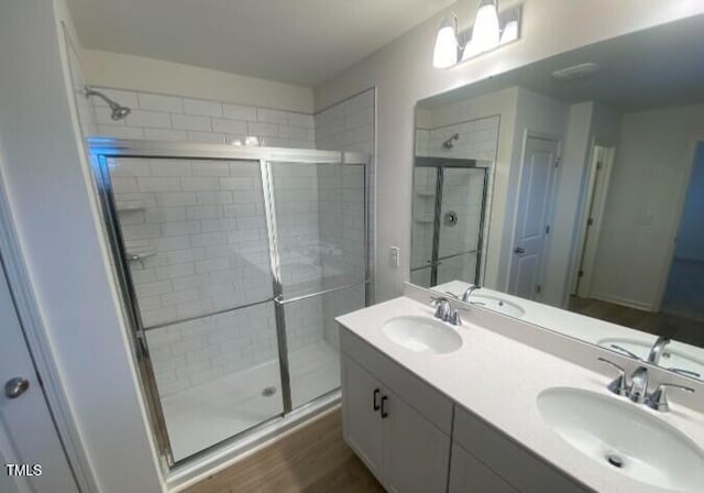 bathroom featuring vanity, a shower with shower door, and wood-type flooring