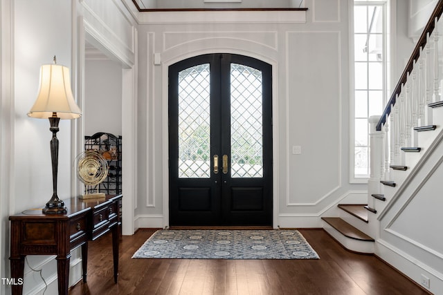 entrance foyer featuring a decorative wall, french doors, and dark wood-style flooring