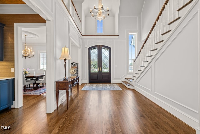 foyer featuring a decorative wall, a healthy amount of sunlight, and an inviting chandelier