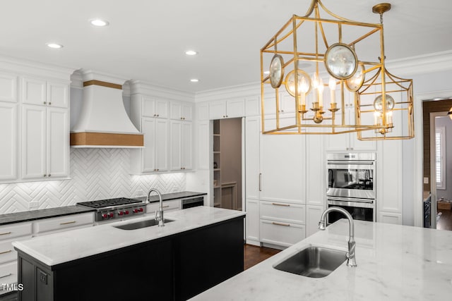 kitchen featuring crown molding, custom range hood, appliances with stainless steel finishes, and a sink