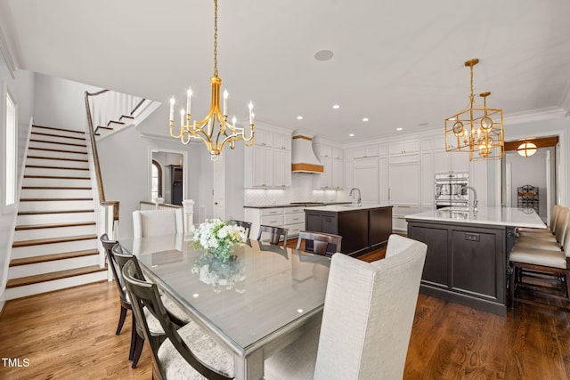 dining space featuring stairway, a notable chandelier, wood finished floors, and ornamental molding