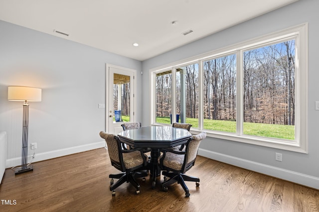 dining area featuring wood finished floors, visible vents, and baseboards