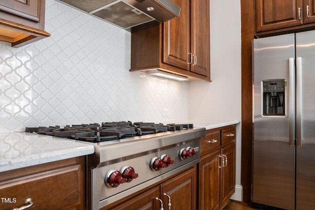 kitchen with backsplash, appliances with stainless steel finishes, custom range hood, and light stone countertops