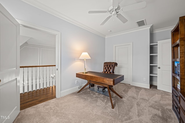 office space with ceiling fan, carpet flooring, visible vents, and ornamental molding