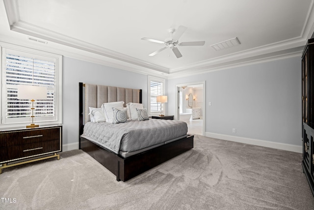 carpeted bedroom featuring a tray ceiling, baseboards, and visible vents