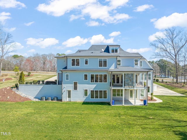 back of property with a yard, driveway, and a patio area