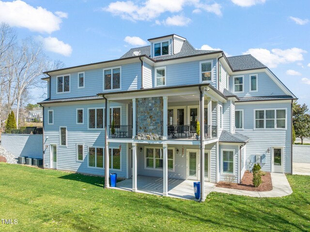 back of property with a patio, a balcony, a yard, and central AC unit