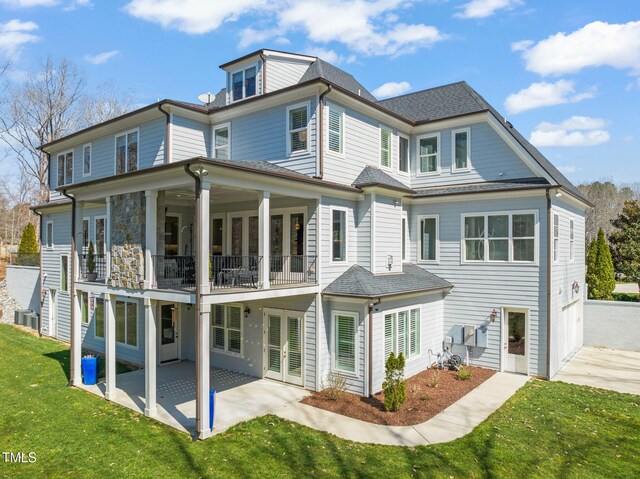 rear view of house with a patio, a yard, cooling unit, french doors, and a balcony