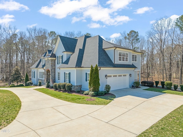 view of side of home with driveway, stone siding, a yard, an attached garage, and a shingled roof