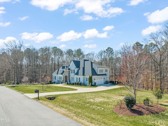 view of front of property with an attached garage, concrete driveway, and a front lawn