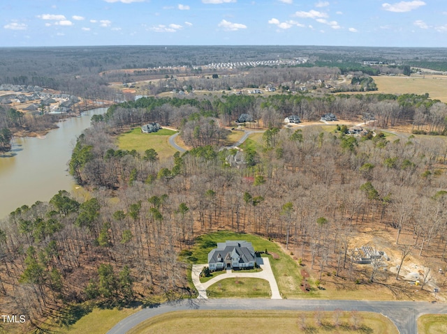 drone / aerial view featuring a forest view and a water view