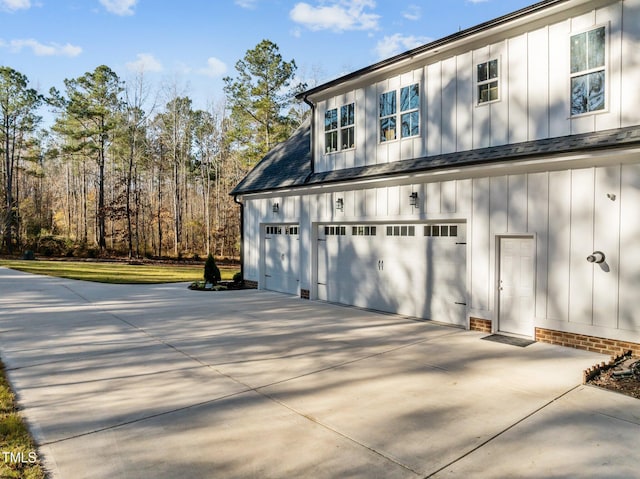 exterior space featuring a garage, roof with shingles, board and batten siding, and concrete driveway