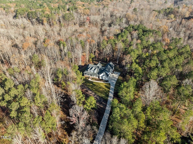 bird's eye view with a wooded view