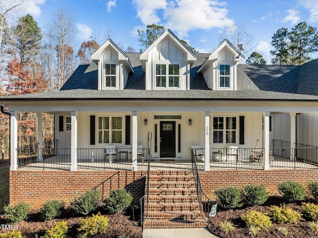 view of front of house with board and batten siding, stairs, covered porch, and a shingled roof