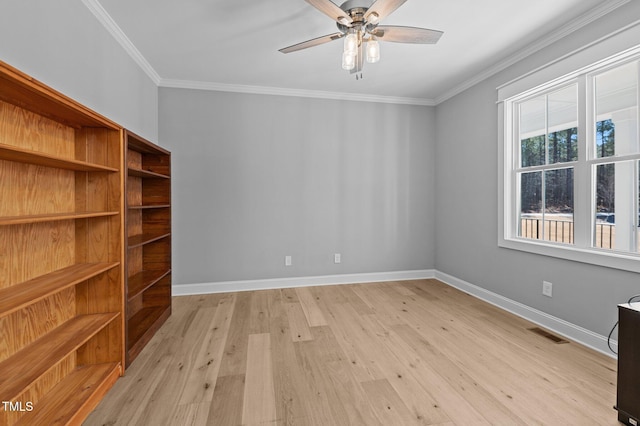 unfurnished room featuring baseboards, visible vents, light wood finished floors, and ornamental molding