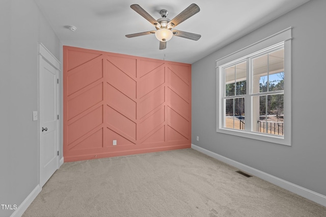 unfurnished room with ceiling fan, baseboards, visible vents, and light carpet