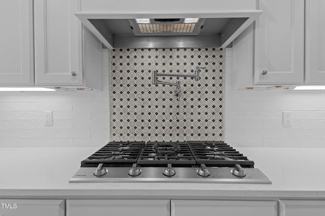 kitchen with stainless steel gas cooktop, tasteful backsplash, extractor fan, and white cabinetry