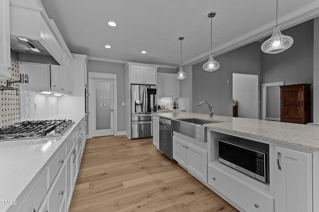 kitchen with light wood-style flooring, a sink, white cabinetry, stainless steel appliances, and crown molding