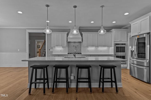 kitchen featuring light wood-style flooring, appliances with stainless steel finishes, white cabinets, and crown molding