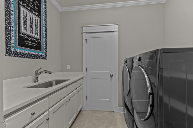 washroom with marble finish floor, ornamental molding, washer and clothes dryer, a sink, and cabinet space