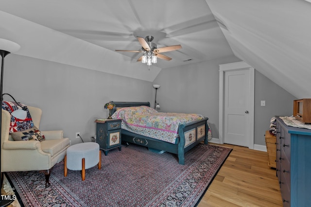 bedroom featuring baseboards, light wood-type flooring, a ceiling fan, and vaulted ceiling