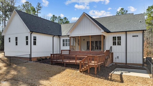 rear view of property with fence, roof with shingles, a wooden deck, a sunroom, and crawl space