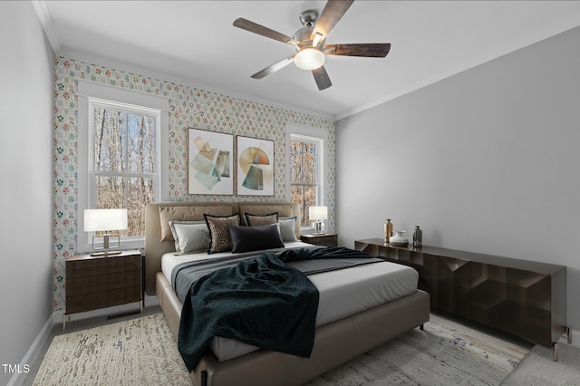 carpeted bedroom featuring wallpapered walls, crown molding, a ceiling fan, and baseboards