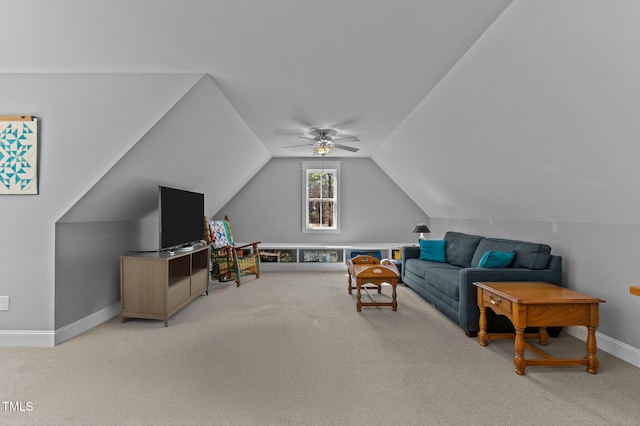 living area featuring baseboards, light colored carpet, a ceiling fan, and vaulted ceiling