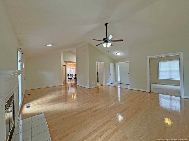 unfurnished living room with high vaulted ceiling, light hardwood / wood-style flooring, and ceiling fan