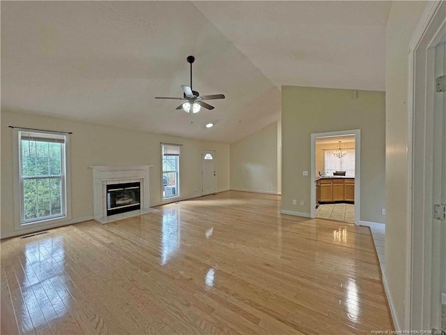 unfurnished living room with ceiling fan, light hardwood / wood-style floors, and high vaulted ceiling