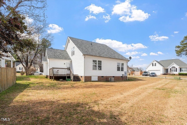 back of property with a lawn, a deck, cooling unit, roof with shingles, and crawl space