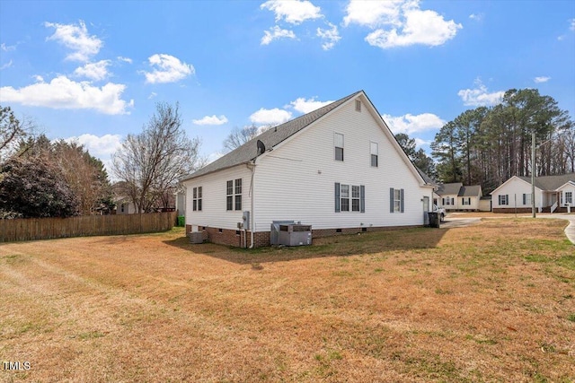 view of side of property with crawl space, central AC unit, a lawn, and fence