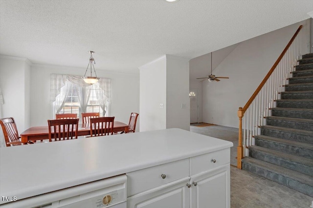 kitchen with white dishwasher, ceiling fan, light countertops, a textured ceiling, and decorative light fixtures