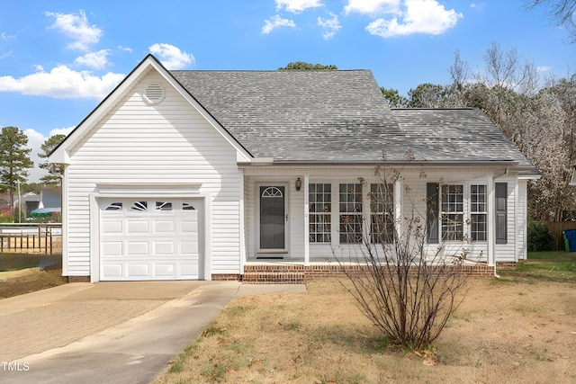 view of front of home with decorative driveway, a garage, and roof with shingles