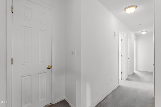 corridor featuring baseboards and carpet floors