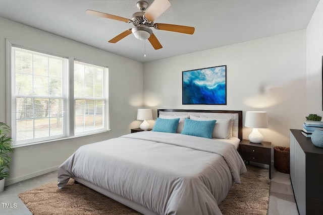 bedroom with baseboards, light colored carpet, and a ceiling fan