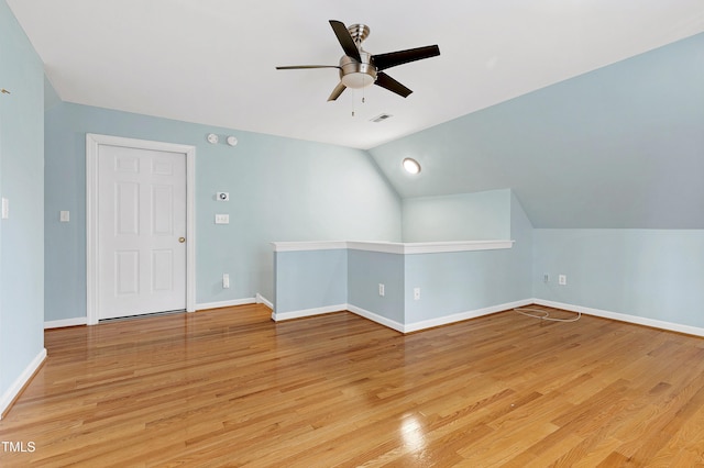 bonus room featuring visible vents, baseboards, ceiling fan, light wood-style flooring, and vaulted ceiling