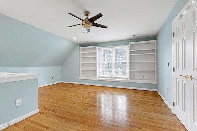 bonus room featuring light wood finished floors, visible vents, baseboards, a ceiling fan, and lofted ceiling