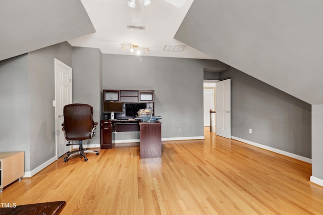 office featuring light wood finished floors, visible vents, baseboards, and vaulted ceiling