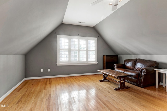 sitting room featuring hardwood / wood-style flooring, baseboards, visible vents, and vaulted ceiling