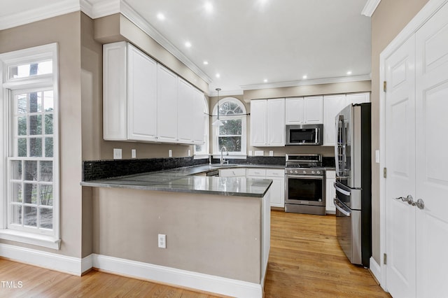 kitchen featuring a peninsula, light wood finished floors, white cabinetry, and appliances with stainless steel finishes